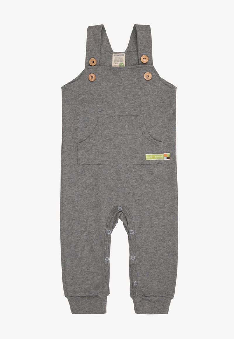 Graue Baumwoll-Latzhosen mit Holzknöpfen, einer Fronttasche und Druckknöpfen am unteren Ende. Mit einem kleinen grünen Etikett an der Seite.