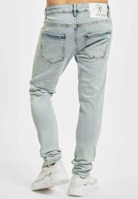 Vaaleansiniset skinny-farkut, joissa on klassinen viiden taskun muotoilu, hienovarainen kuluminen ja merkkilappu takavyötäröllä.