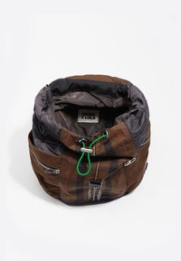 Rjava in siva najlonska nahrbtnik s karirastim vzorcem. Ima zadrge, zeleno zanko in zategnjen vrh. Znotraj označen z "BIMBA Y LOLA."