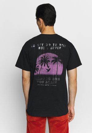 T-shirt in cotone nero con stampa grafica raffigurante un tramonto viola, palme e testo sul retro; vestibilità rilassata e maniche corte.