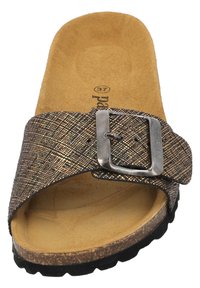 Brązowe klapki z teksturowanym paskiem z metalowymi akcentami, metalową klamrą i wyściełanym wnętrzem; gumowa podeszwa zapewniająca chwyt.