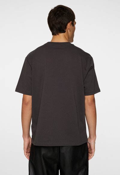 Mörkgrå oversized kortärmad t-shirt i bomull, med rund halsringning och en avslappnad passform, sedd bakifrån.