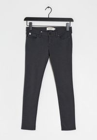 Donkergrijze skinny jeans van een zachte stof. Beschikt over vijf zakken, riemlussen en een subtiele merketiket op de tailleband.
