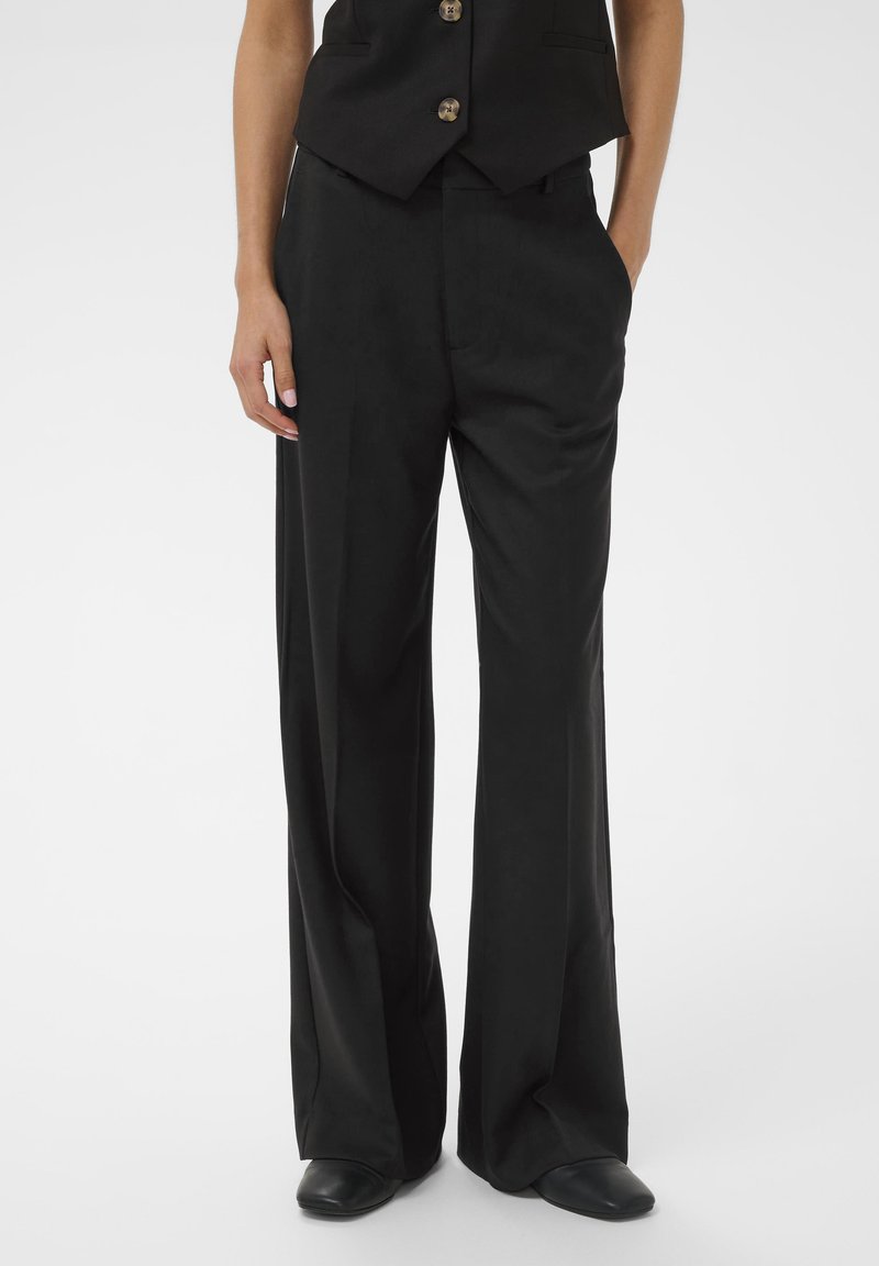Black wide-leg trousers made of smooth fabric, featuring a relaxed fit and front pockets. The waistband has subtle stitching details.