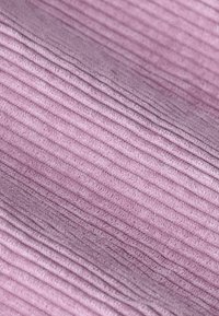 Tissu texturé en rose doux, présentant un motif à côtes ondulées. La surface a un léger éclat, mettant en valeur sa qualité tactile.