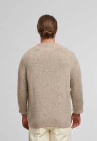 Beige gestrickter Pullover mit strukturiertem Finish, featuring einem Rundhalsausschnitt und langen Ärmeln, von hinten gezeigt.