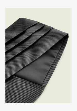 Czarny teksturowany krawat z wzorem pepitki, z zakładkami. Od spodu gładki czarny materiał, stanowiący kontrastujący element designu.