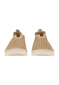Zapatos de tela de color beige sin cordones, con un upper texturizado, aberturas elásticas y una suela de goma de color claro con un patrón de zigzag.