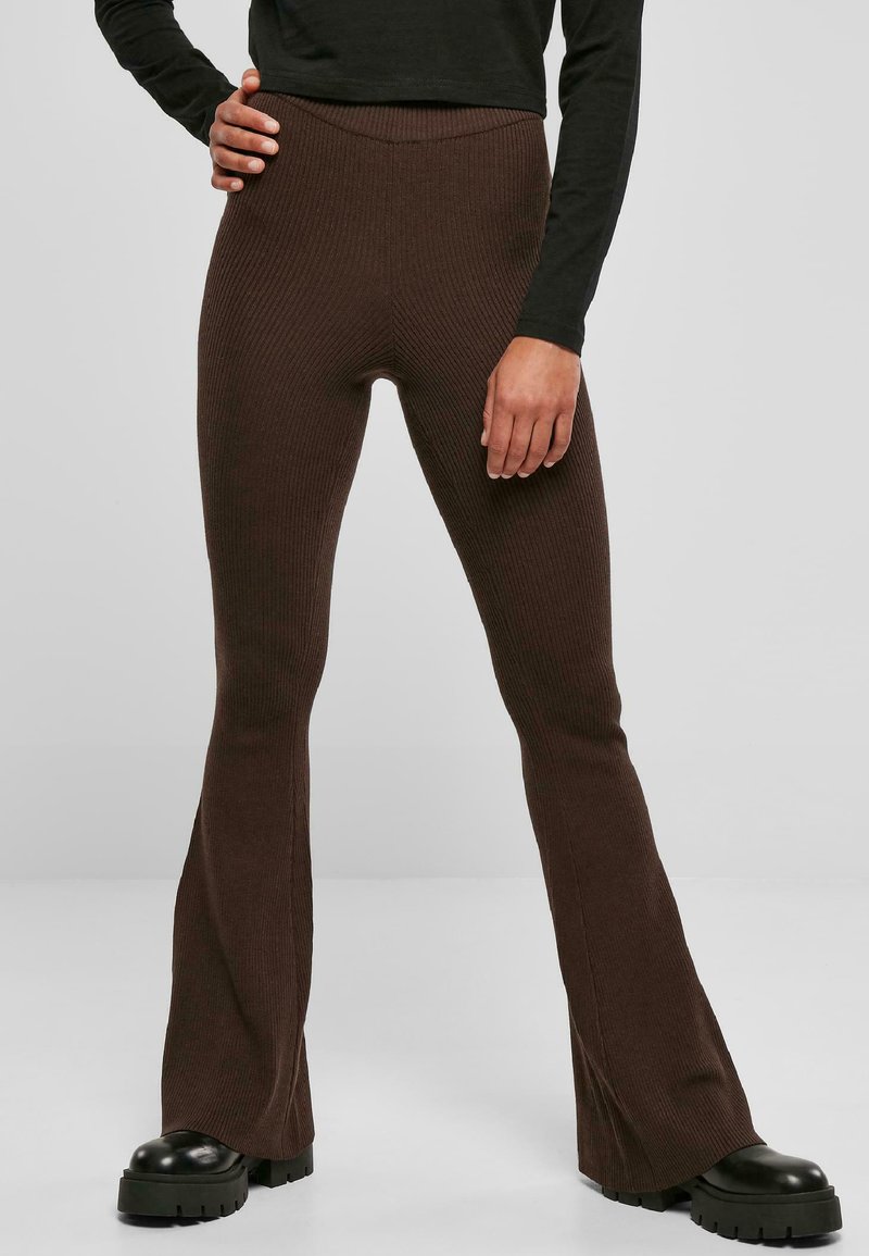 Barna bordázott, bővített leggings, magas derékkal, rugalmas anyagból készült. Fekete, vastag talpú cipőkkel párosítva.