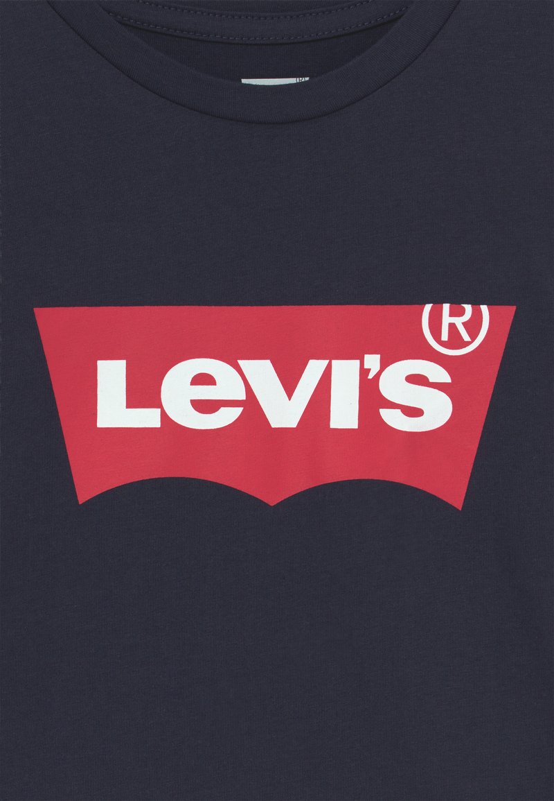 T-shirt bleu marine avec un logo Levi's rouge en forme arrondie, comportant un texte blanc. Encolure ronde et tissu en coton doux et texturé.