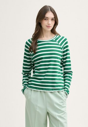 T-shirt à manches longues rayé vert et blanc avec un col rond et des manches raglan, fabriqué en tissu doux. Associé à un pantalon léger en menthe.