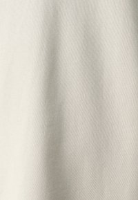 Απαλή γκρίζα υφή υφάσματος, λεια με ελαφριά πλέξη. Ομοιόμορφο χρώμα χωρίς ορατές σημάνσεις ή σχέδια. Μαλακό και ευέλικτο υλικό.