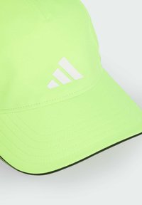 Gorra verde neón hecha de tela, con un diseño estructurado, visera curva y un logotipo de tres rayas blancas en la parte frontal.