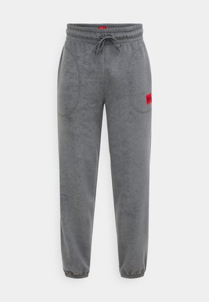 Grijze joggingbroek gemaakt van zacht materiaal, met een elastische tailleband met verstelbare trekkoorden en zijzakken. Rode labelaccent op de heup.
