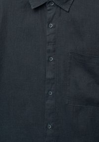 Camicia button-up in lino grigio scuro con colletto, sei bottoni e una tasca sul petto con una sottile texture.