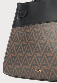 Sac à main noir et marron avec un motif géométrique, un dessus en cuir lisse, une surface texturée, et un accent du logo doré "ALDO".