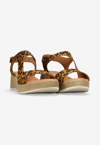 Sandalias de cuña con estampado de leopardo, correas entrecruzadas, material de ante color tostado, plantilla de esparto texturizada y suela de goma blanca.