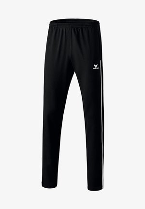 Pantalon de sport noir avec taille élastique, bandes blanches sur les côtés et logo Erima sur la cuisse supérieure.