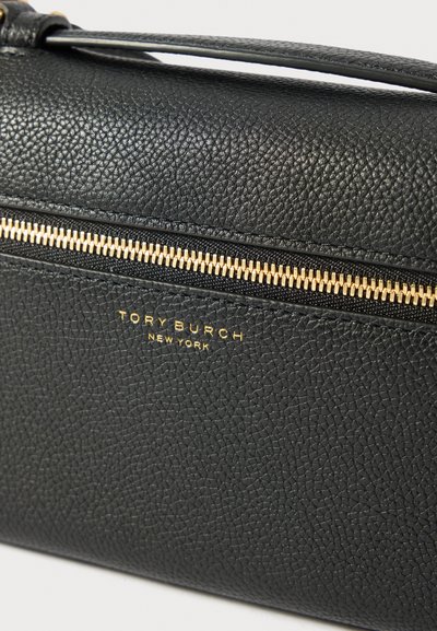 Musta teksturoitu nahkainen Tory Burch -laukkukultaisella vetoketjulla ja logolla, joka on kuvioitu vetoketjun alapuolelle etupinnalle.