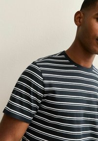 Short-sleeve T-shirt featuring a black background with white horizontal stripes, made of soft cotton material, crew neckline, and regular fit.