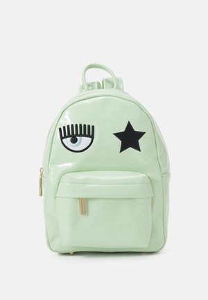 Petit sac à dos vert menthe avec une grande poche avant, présentant une étoile noire et un design stylisé de cache-œil à l'avant.