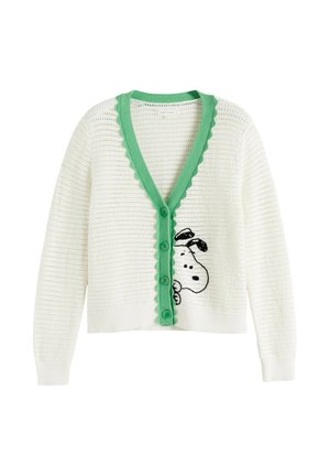 Cardigan bianco lavorato a maglia con rifinitura smerlata verde e bottoni, con un volto di cane bianco e nero che spunta dalla parte bassa davanti.
