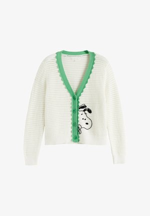 Cardigan bianco lavorato a maglia con rifinitura smerlata verde e bottoni, con un volto di cane bianco e nero che spunta dalla parte bassa davanti.