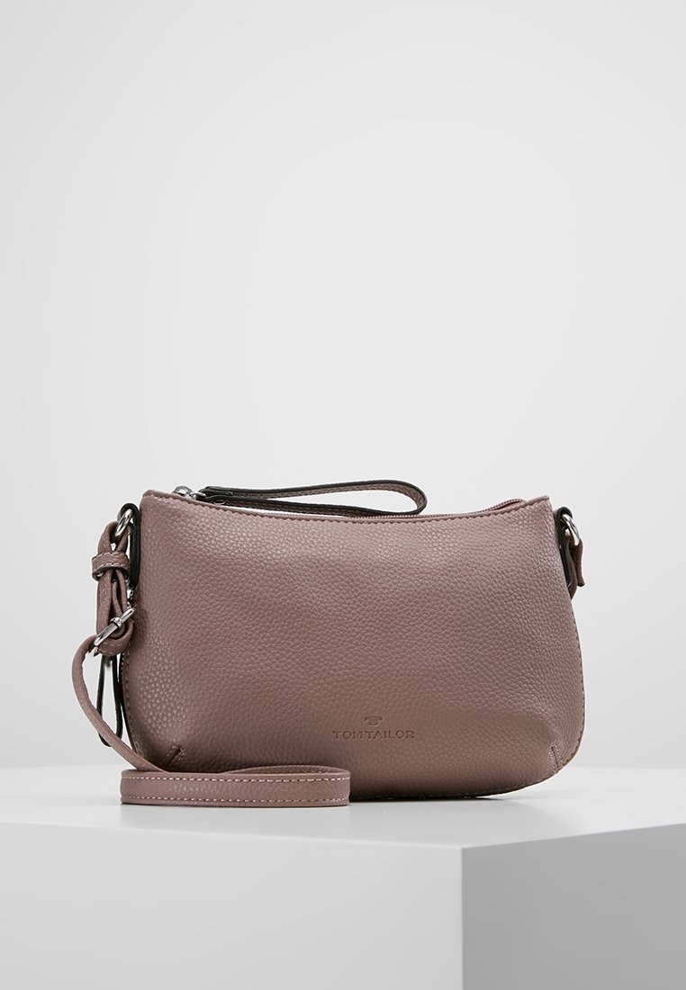 Sac à bandoulière en cuir rose avec texture granuleuse, fermeture zippée, bandoulière réglable et logo de la marque à l'avant. Design compact et structuré.