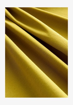 Puuvillakangas rauhallisessa oliivinvihreässä värissä, jossa on sileä ja pehmeä rakenne, sekä taitteita ja ryppyjä, jotka luovat syvyyttä ja ulottuvuutta.