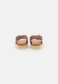 Brown leather sandals with buckle, natural fiber espadrille sole, open toe design, and smooth insoles for comfort.
