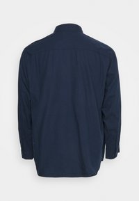 Námorně modrá košile s dlouhým rukávem, s límcem na knoflíky, rovný lem a manžety na knoflíky, s hladkou texturou látky.