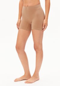 Sous-vêtement beige sans couture de style court, avec une large ceinture élastique, une texture côtelée et une longueur mi-cuisse, conçu pour le confort et la liberté de mouvement.
