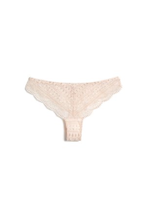 String de femme en dentelle rose clair avec motifs floraux et géométriques ainsi que des bords festonnés, posé à plat sur un fond blanc.