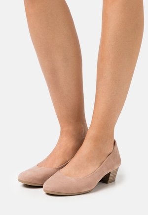 Zapatos de tacón de ante beige con punta redondeada y tacón de madera cónico de altura media. Textura suave con un diseño minimalista.