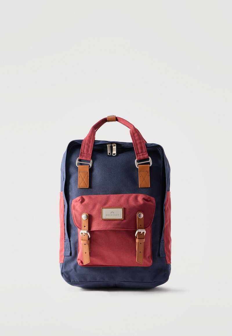 Μπλε και κόκκινο σακίδιο πλάτης με μπροστινή τσέπη που διαθέτει δύο καφέ λουράκια με αγκράφες και κλείσιμο με φερμουάρ στην κορυφή.