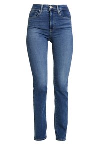 Vaqueros de mezclilla azules de tiro alto con un ajuste Slim, que presentan bolsillos frontales y un cierre de botón clásico. Lavado uniforme con un ligero desgaste.