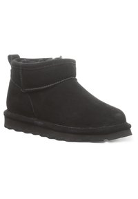 Schwarze Wildleder-Ankle Boots mit abgerundetem Zehenbereich, gebogenem oberen Saum und einer strukturierten Gummisohle mit wellenartigen Mustern. Weiche Innenauskleidung.