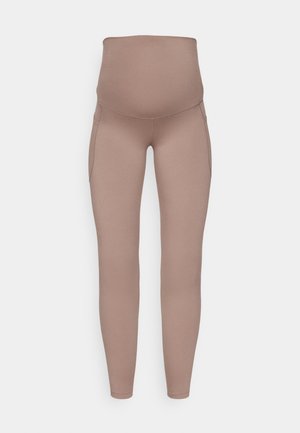 Leggings premaman in morbido tessuto elastico, caratterizzati da una vita alta e due tasche laterali. Il colore è un beige tenue con una superficie liscia.