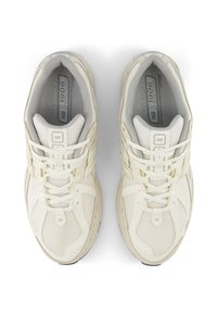Pair of cream-colored New Balance 1906 sneakers with mesh and leather uppers, laces tied, viewed from above on a white background.