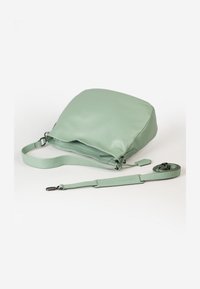 Borsa a spalla in pelle verde menta con una forma morbida e arrotondata, tracolla regolabile e chiusura a zip. Presenta una superficie liscia e un design semplice.