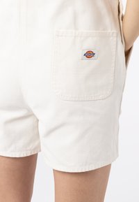 Kremfargede denimshorts med en baklomme som har en fargerik Dickies-logo-patch. Skreddersydd passform med rene sømdetaljer.