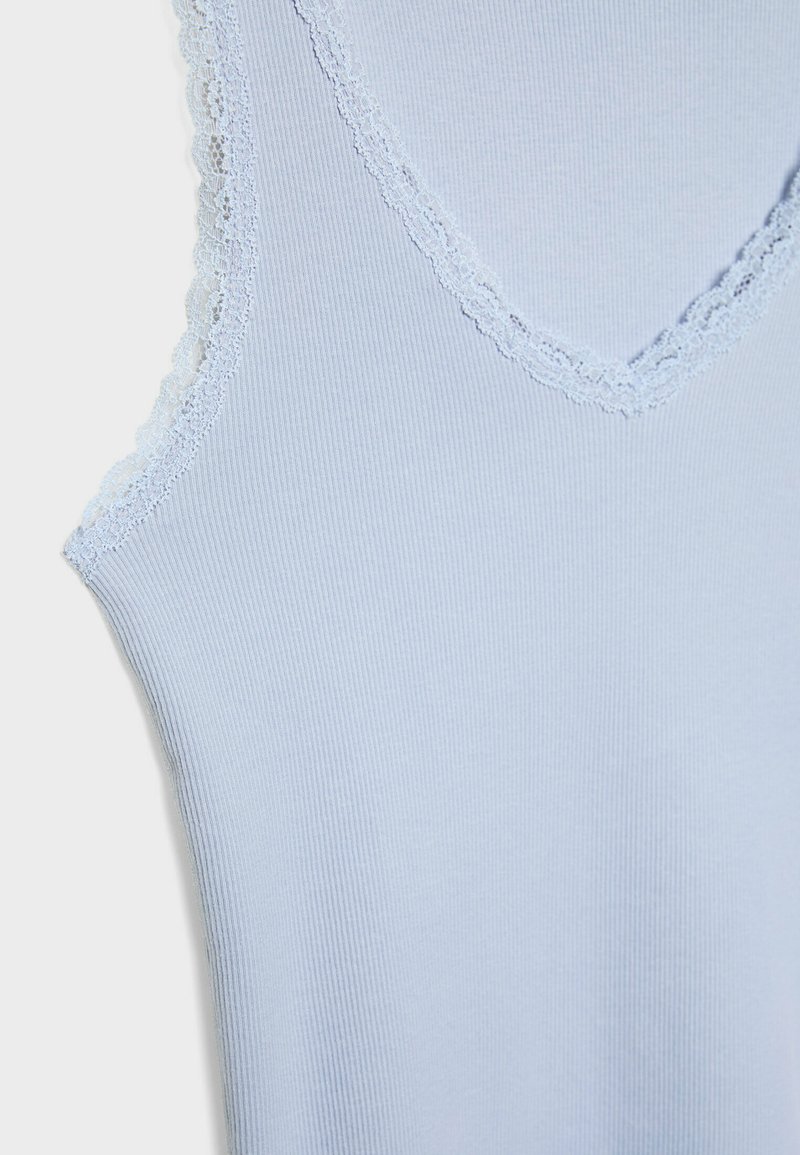 Débardeur bleu clair à côtes avec un col en V et une bordure en dentelle au niveau de l'encolure et des emmanchures. Texture lisse, design ajusté.