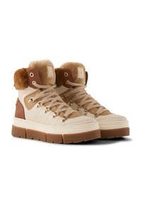 Beige und braune knöchelhohe Stiefel mit dicken Gummisohlen, gepolsterten Kragen, goldenen Ösen und einem weichen Pelzfutter, das an den Öffnungen sichtbar ist.