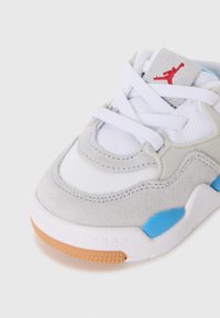 Baskets en suède gris et mesh blanc avec accents bleus et logo rouge. Elles possèdent des lacets blancs et une semelle en caoutchouc texturée. Bout arrondi, design athlétique.