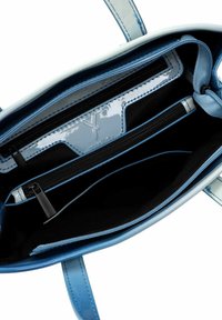 Gaiši zils somiņš ar spīdīgu apdari, kuram ir divi rāvējslēdzēju kabatas un melna iekšpuse. Ietver teksturētu šuvumu un mīkstas siksnas.