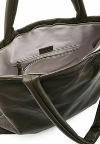 Borsa tote in pelle verde scuro con motivo trapuntato a diamante, con interno chiaro e tasca con zip per riporre oggetti.