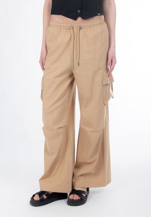 Beige cargobukser med vide ben, elastisk talje, snørelukning og sidelommer. Fremstillet af letvægtsstof.