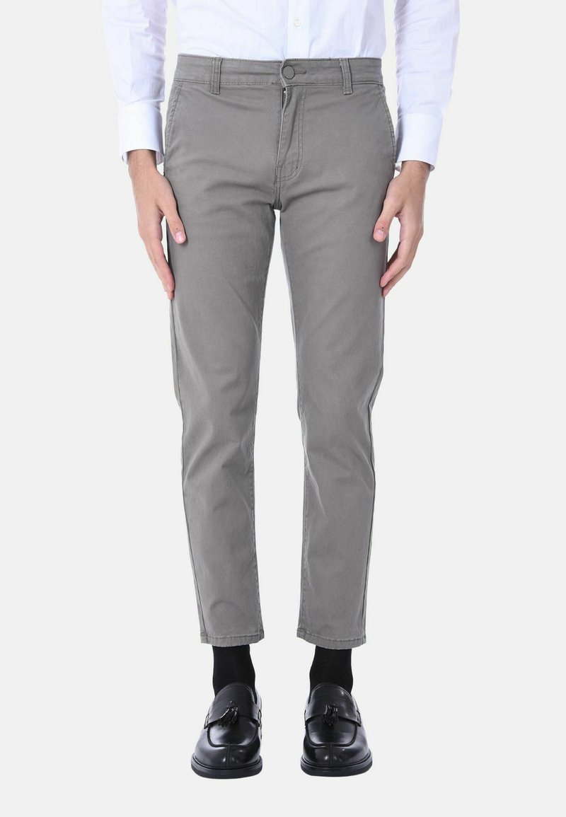 Pantaloni chino in cotone grigi con una vestibilità slim, dotati di zip e chiusura con bottone, tasche laterali e orli rifiniti. Indossati con mocassini neri.