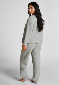 Grå stickad myswear-set med en sweatshirt i avslappnad passform och ribbade muddar samt matchande byxor med dragsko i midjan och sidofickor.