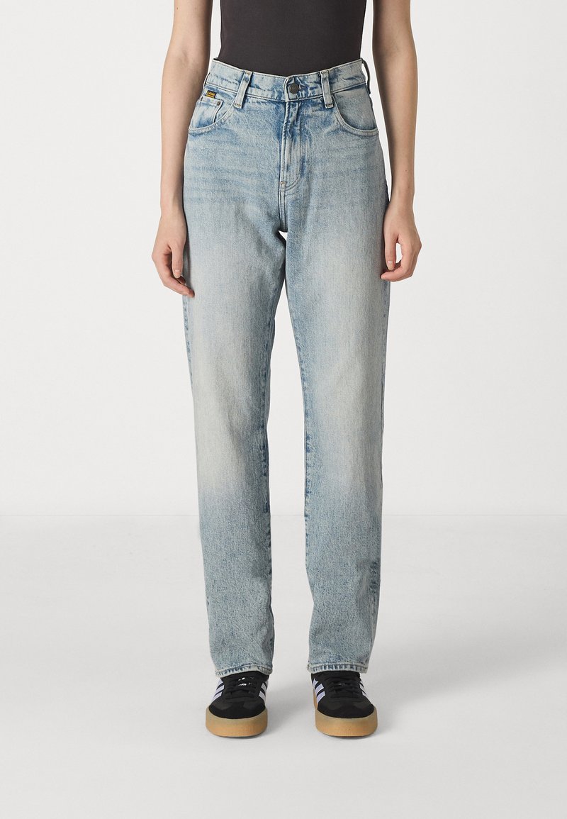 Svetlomodré džíny s rovného strihu, vysokým pásom a piatimi vreckami; vyblednutá textúra a viditeľné švy.